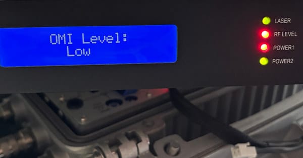 CATV transmitter LED front panel displaying OMI LOW warning indicating insufficient RF input level